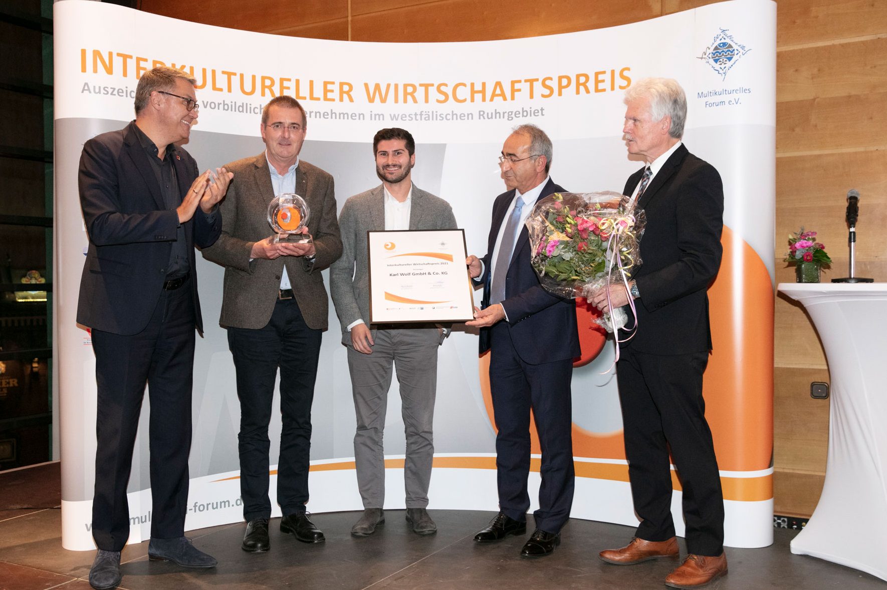 Preisverleihung für den Interkulturellen Wirtschaftspreis mit strahlenden Gewinnern. Jens und Niels Baldauf stehen in der Mitte